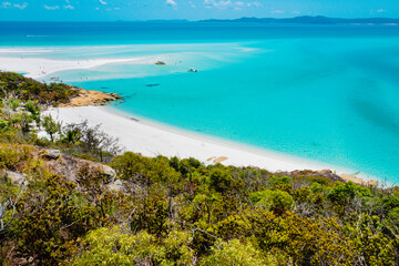 Fototapeta na wymiar Boats transporting tourists to Whitehaven Beach is on Whitsunday Island. . The beach is known for its crystal white silica sands and turquoise colored waters. Autralia, Dec 2019