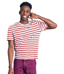 Young african american man wearing casual clothes smiling doing phone gesture with hand and fingers like talking on the telephone. communicating concepts.