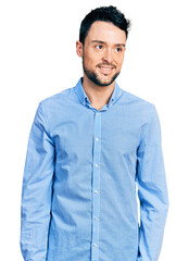 Hispanic man with beard wearing casual business shirt looking away to side with smile on face, natural expression. laughing confident.