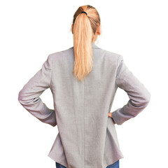 Young beautiful blonde woman wearing elegant jacket standing backwards looking away with arms on...