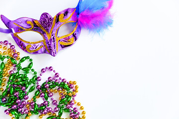 Carnival mask with feathers and colorful beads on white background. Mardi Gras or Fat Tuesday...