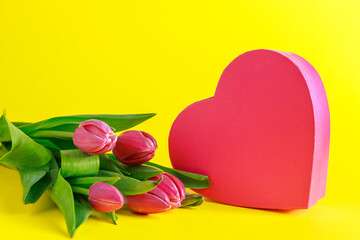 Tulips and pink heart on yellow background.