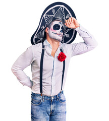 Man wearing day of the dead costume over background stretching back, tired and relaxed, sleepy and...