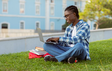 Obraz premium black student guy typing on laptop having lecture at park
