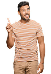 Naklejka premium Handsome hispanic man wearing casual clothes pointing finger up with successful idea. exited and happy. number one.