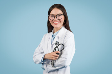 Cheerful doctor holding stethoscope on blue