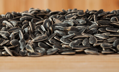 Natural background of sunflower seeds in hulls on wooden surface. Popular snack food