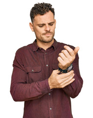 Young hispanic man wearing casual clothes suffering pain on hands and fingers, arthritis...