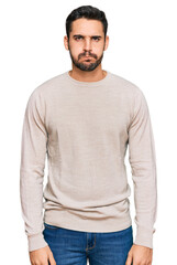 Fototapeta premium Young hispanic man wearing casual clothes puffing cheeks with funny face. mouth inflated with air, crazy expression.