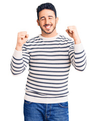 Naklejka premium Young hispanic man wearing casual clothes excited for success with arms raised and eyes closed celebrating victory smiling. winner concept.