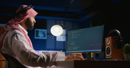 Arab technician writing script code on computer screen inputting commands on terminal. Middle...