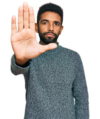 Young african american man wearing casual clothes doing stop sing with palm of the hand. warning...