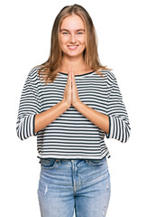 Beautiful blonde woman wearing casual clothes praying with hands together asking for forgiveness smiling confident.