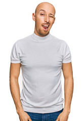 Obraz premium Bald man with beard wearing casual white t shirt winking looking at the camera with sexy expression, cheerful and happy face.