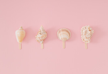 Trendy summer layout of sea shells with ice cream stick on light peachy pink background. Minimal...