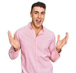 Fototapeta premium Hispanic young man wearing casual clothes celebrating victory with happy smile and winner expression with raised hands