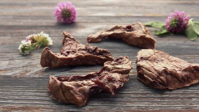 Natural and healthy dog pet food on the wooden table. Dried beef lung as natural pet food