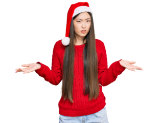 Young chinese woman wearing christmas hat clueless and confused with open arms, no idea concept.