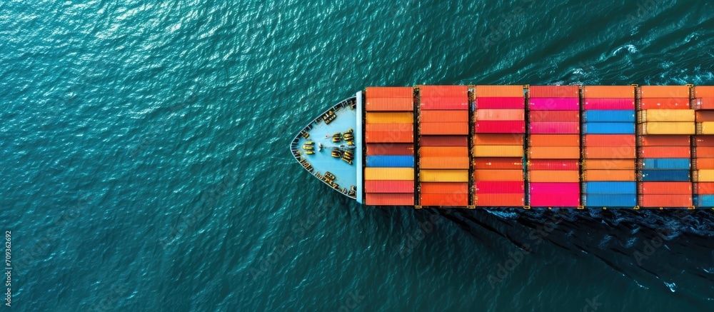 Poster a top-down photo of a container ship with colorful containers in the open ocean.