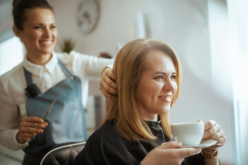 40 years old hair salon employee in beauty salon cutting hair