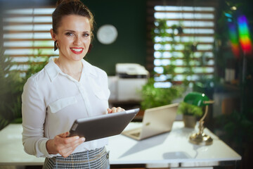 woman real estate agent in green office using digital tablet