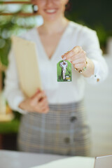 Closeup on young female realtor in modern green office