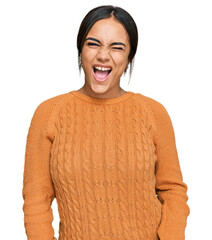 Young brunette woman wearing casual winter sweater winking looking at the camera with sexy...