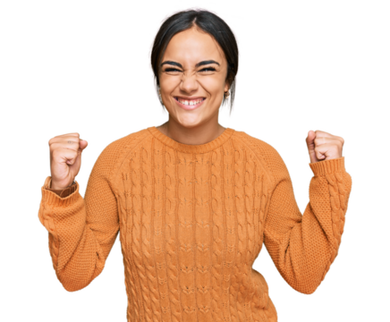 Young brunette woman wearing casual winter sweater celebrating surprised and amazed for success with arms raised and open eyes. winner concept.