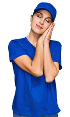 Young hispanic girl wearing delivery courier uniform sleeping tired dreaming and posing with hands together while smiling with closed eyes.