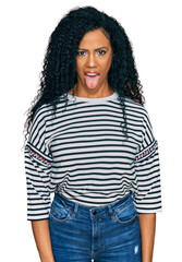 Middle age african american woman wearing casual clothes sticking tongue out happy with funny expression. emotion concept.