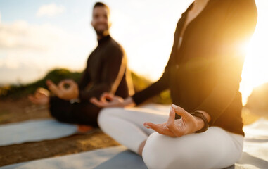 Close-up of couple in lotus position practicing meditation
