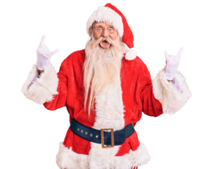 Old senior man with grey hair and long beard wearing traditional santa claus costume shouting with crazy expression doing rock symbol with hands up. music star. heavy music concept.