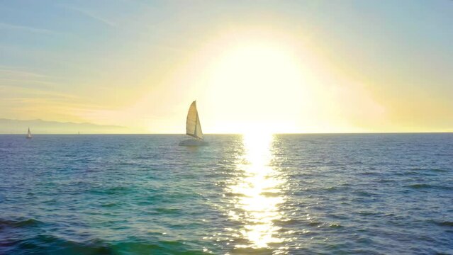 Sailboat Cruising Towards Sunset Horizon on Peaceful Ocean Waters. 