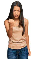 Obraz premium Beautiful hispanic woman wearing casual clothes angry and mad raising fist frustrated and furious while shouting with anger. rage and aggressive concept.