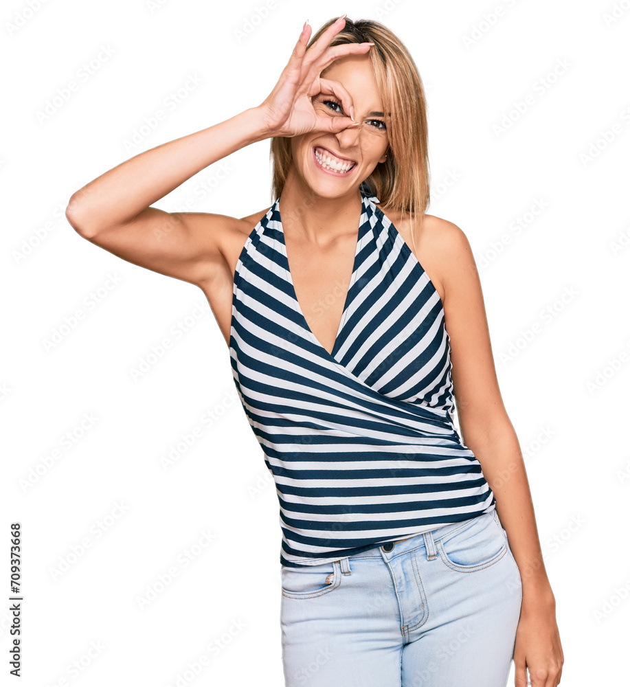 Wall mural Beautiful blonde woman wearing casual clothes smiling happy doing ok sign with hand on eye looking through fingers