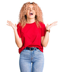 Young blonde woman with curly hair wearing casual red tshirt celebrating mad and crazy for success...
