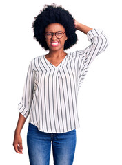 Young african american woman wearing casual clothes and glasses confuse and wonder about question. uncertain with doubt, thinking with hand on head. pensive concept.