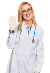 Beautiful caucasian woman wearing doctor uniform and stethoscope showing and pointing up with fingers number five while smiling confident and happy.