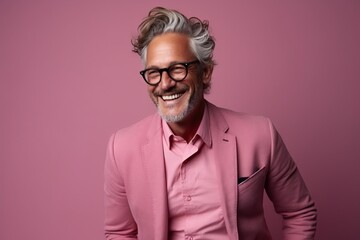 Portrait of a smiling senior man in a pink suit and glasses