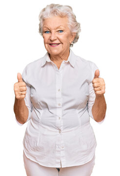 Senior grey-haired woman wearing casual clothes success sign doing positive gesture with hand, thumbs up smiling and happy. cheerful expression and winner gesture.