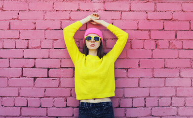 Portrait of stylish young teenager girl wearing vivid colorful clothes, knitted yellow sweater and...
