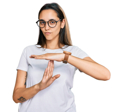 Young hispanic woman wearing casual white t shirt doing time out gesture with hands, frustrated and serious face