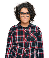 Young hispanic woman with curly hair wearing casual clothes and glasses with serious expression on face. simple and natural looking at the camera.