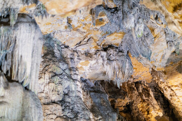 Lime stone stalactites in the cave - mineral formation that hangs from the cave's ceiling