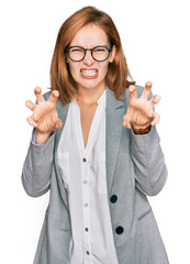 Young caucasian woman wearing business style and glasses smiling funny doing claw gesture as cat,...