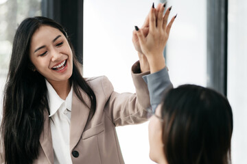 Obraz premium Happy creative business people are motivated, giving high five and celebration successful deal. Cooperation Meeting Partnership Career growth Team building Successful business.