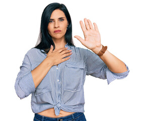 Young caucasian woman wearing casual clothes swearing with hand on chest and open palm, making a...