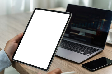 A businessman holds a mockup. iPad digital tablet with blank screen Mockup replaces your design mockup in the office. - obrazy, fototapety, plakaty