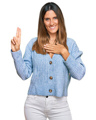 Young woman wearing casual clothes smiling swearing with hand on chest and fingers up, making a loyalty promise oath