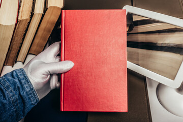 Photo of antiquarian male person in white gloves holding a red book in their hand.